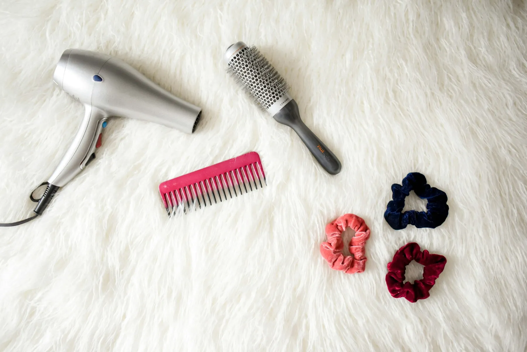 A hair dryer, a round brush and a comb