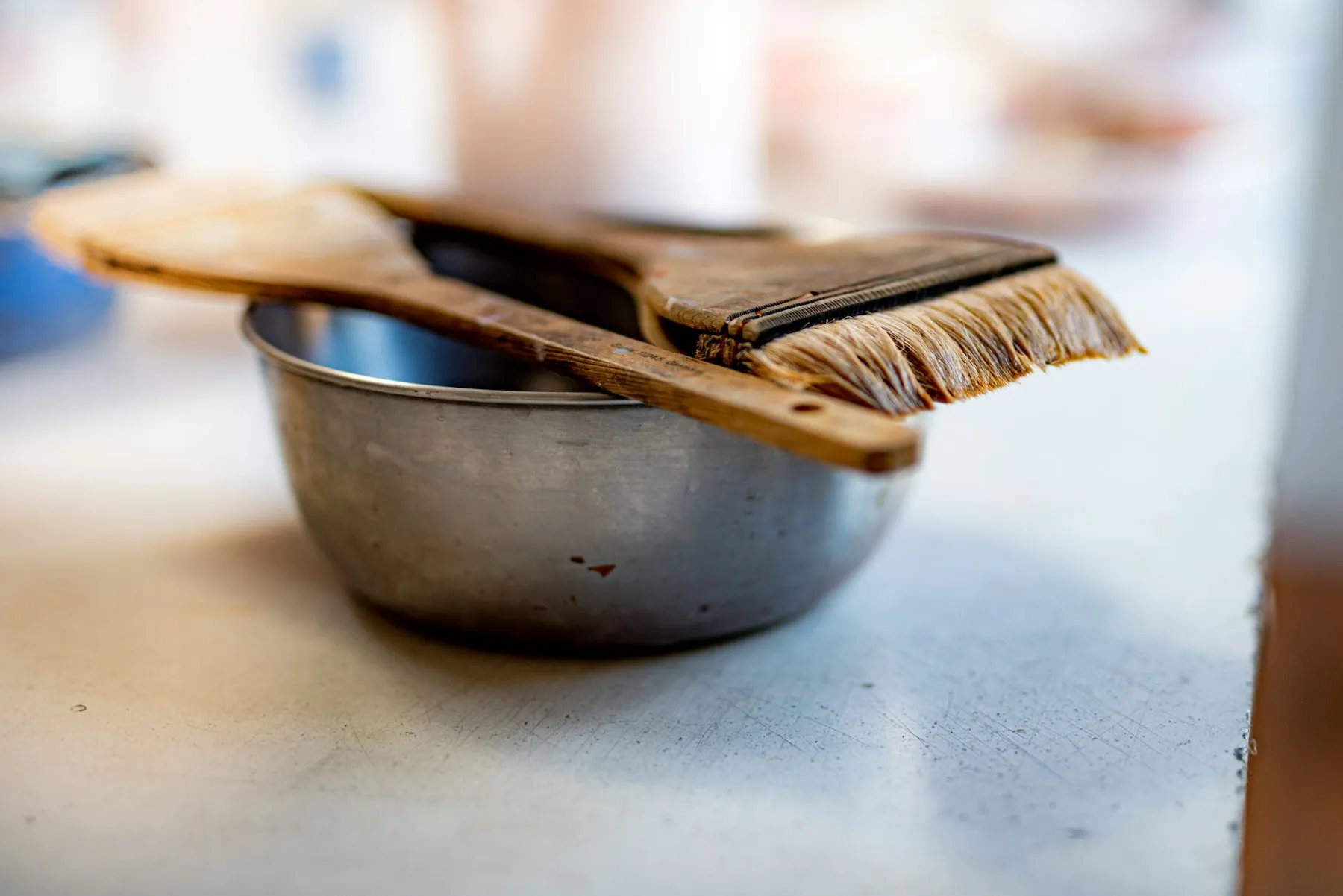 A mixing bowl with a wide brush resting on top